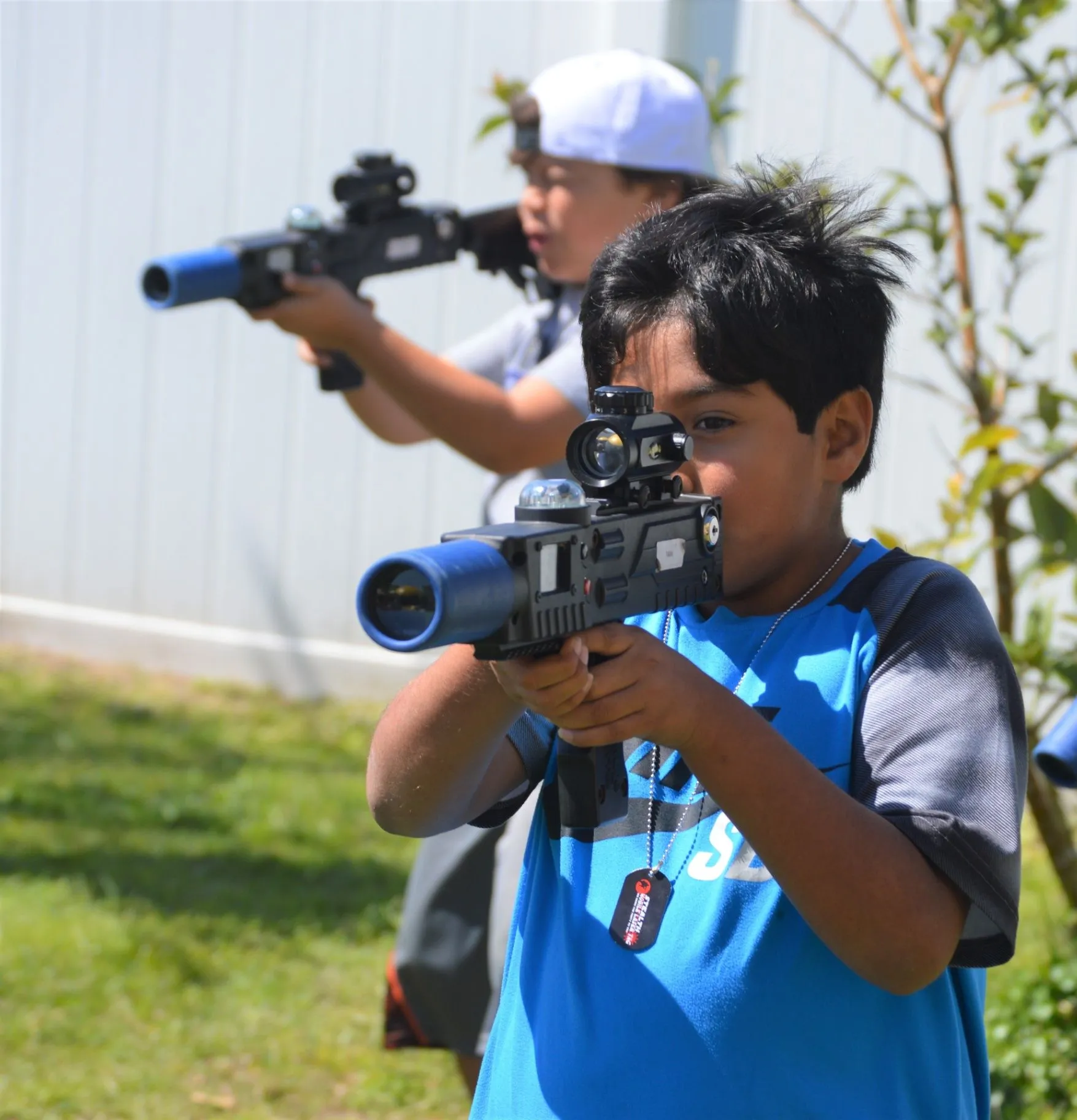Two boys playing laser tag outdoors